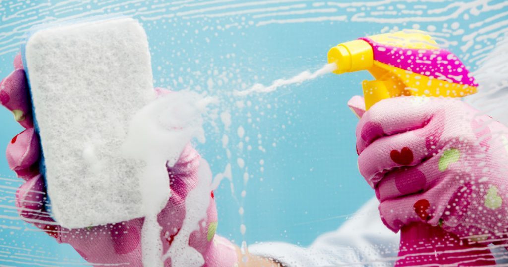 Close-Up of spray bottle spraying cleaning fluid and sponge